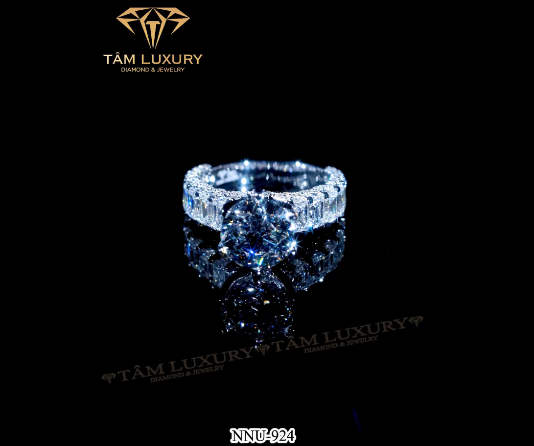 Nhẫn nữ vàng 750 đính kim cương VVS+ "Faiga" - Mã NNU954 là sự kết hợp hoàn hảo của phong cách hiện đại và cổ điển, xung quanh nhẫn được nhà chế tác như một đóa hoa lấp lánh kèm theo đó là viên chủ tôn lên được sự sáng soi như ngôi sao sáng chiếc nhẫn giúp người sỡ hữu như mang 1 thiên hà trên tay thể hiện sự sang trọng đẳng cấp.Chất liệu : Vàng ý 750 Size kim cương :  Tròn : 1.0mm - 2.3.mm Chất lượng kim cương : VVS+ Ổ chủ : 4.5mm Nhẫn nữ vàng 750 đính kim cương VVS+ "Enchement" - Mã NNU924 sang trọng